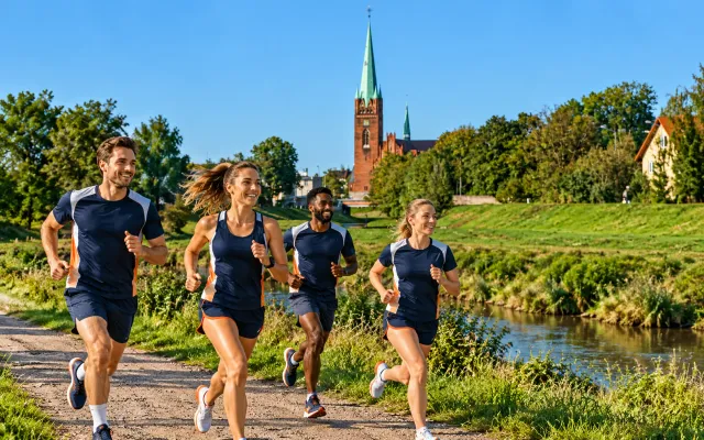 Running illustration for Legnica: adult runners in a destination setting; not the featured race edition or its course.